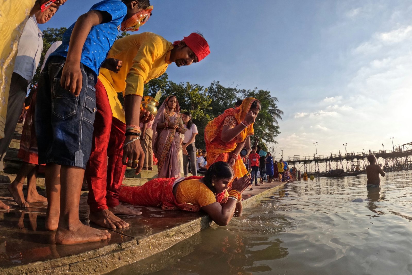 a group of people standing around a body of water